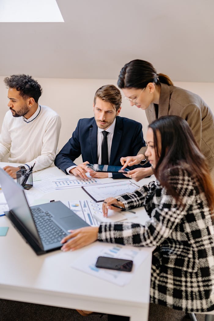 about-us Professionals engaged in a meeting discussing plans in a modern office setting.