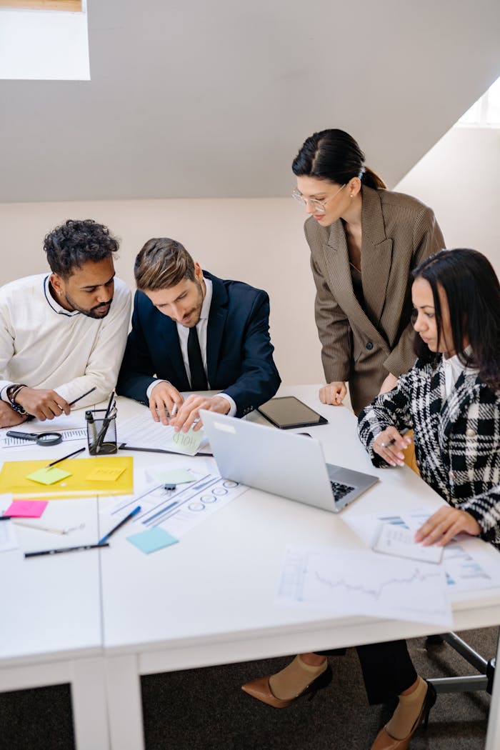 why-choose-us Business team brainstorming ideas at a workspace, using a laptop for planning.
